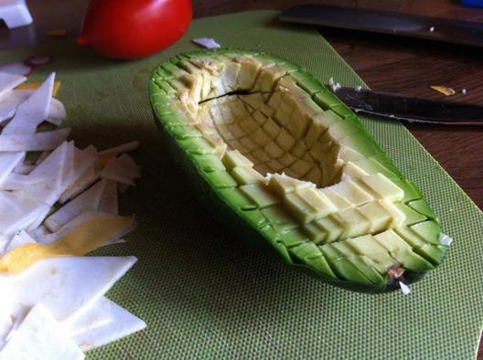 An avocado sliced to small cubes with a dull knive, so the skin stays intact