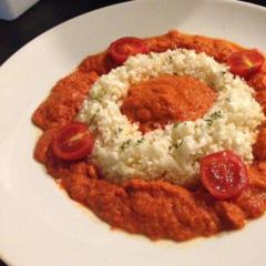 Cauliflower "rice" with a red peppers, carrot, avocado, parsley sauce with a touch of lemon juice and cocktail tomatoes as garnish