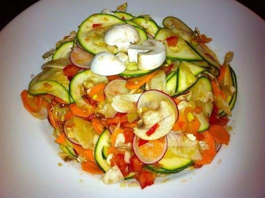 Raw salad made of zucchini, radish, fennel, carrots and button mushrooms with tomato and avocado pieces massaged in it...