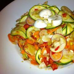Raw salad made of zucchini, radish, fennel, carrots and button mushrooms with tomato and avocado pieces massaged in it...