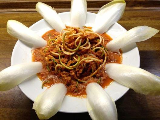 Zucchini noodles with chicory leaves and a sauce of red pepper, avocado, some stalks celery, lemon and some cocktail tomatoes