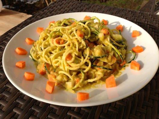 Zucchini noodles with pieces of carrot and kohlrabi and a sauce of yellow pepper, avocado, lemon and some stalks of celery.
